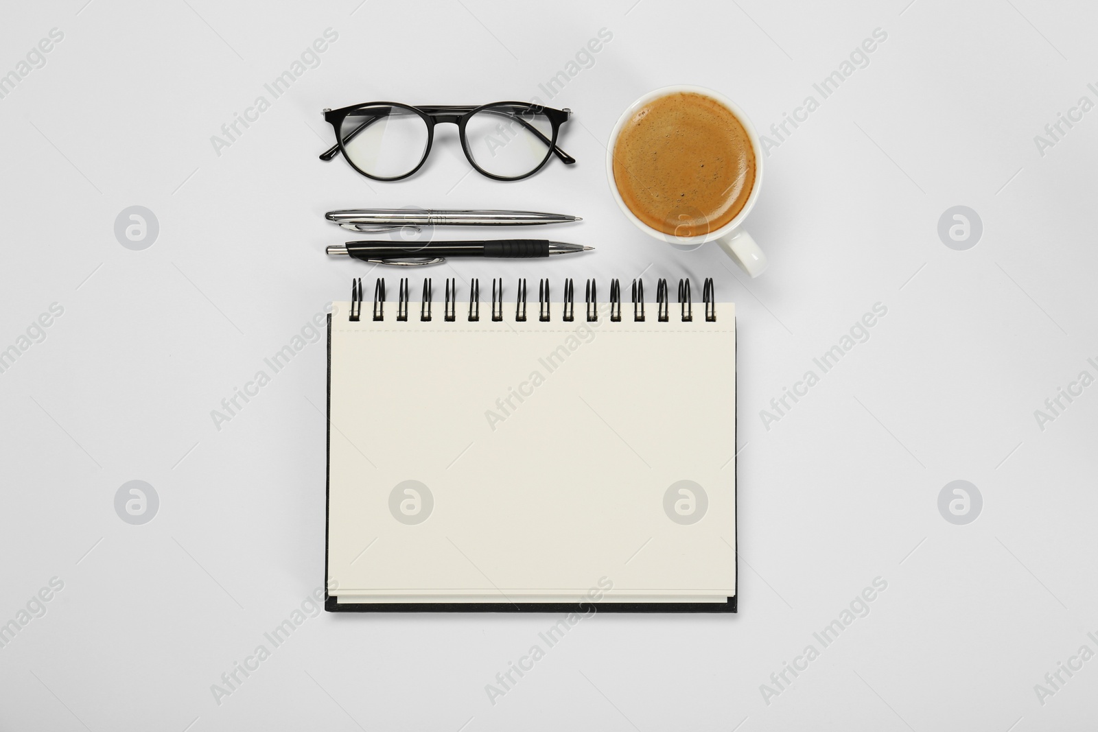 Photo of Flat lay composition with open notebook and coffee on white table