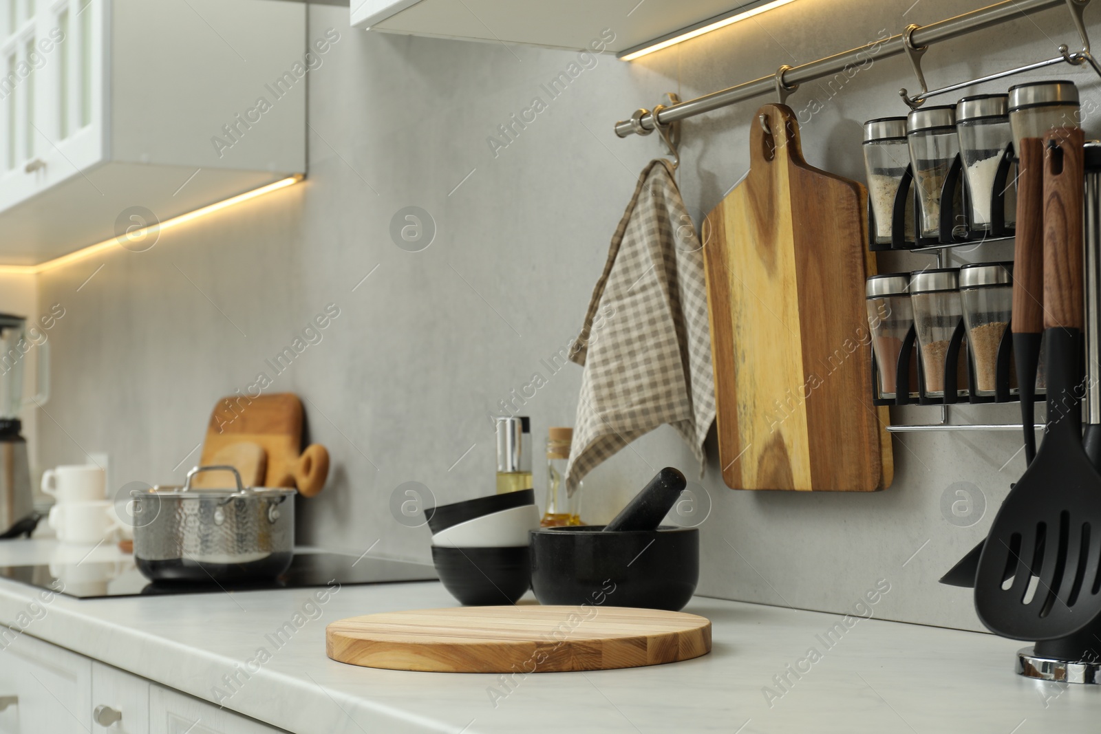 Photo of Wooden cutting boards and other cooking utensils on white countertop in kitchen