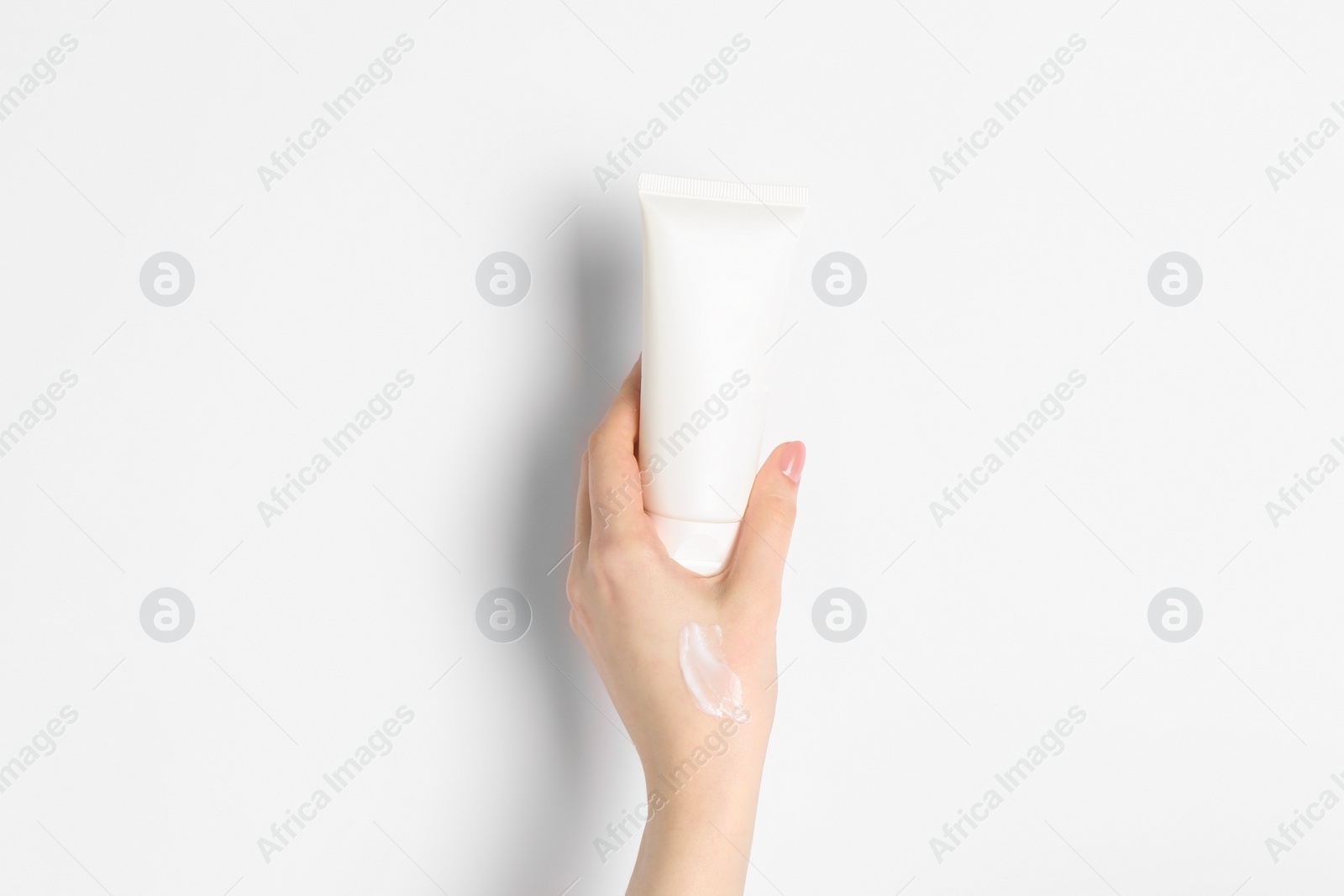 Photo of Woman with tube of cream on white background, closeup