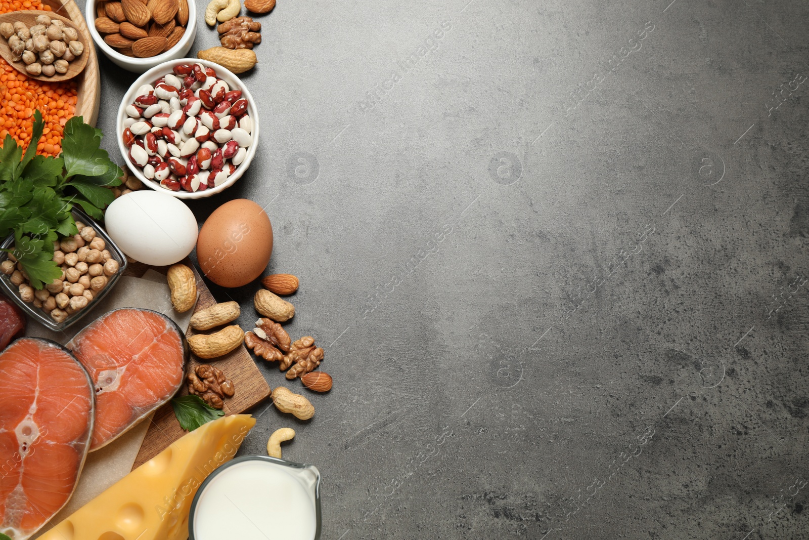 Photo of Products rich in protein on grey table, flat lay. Space for text