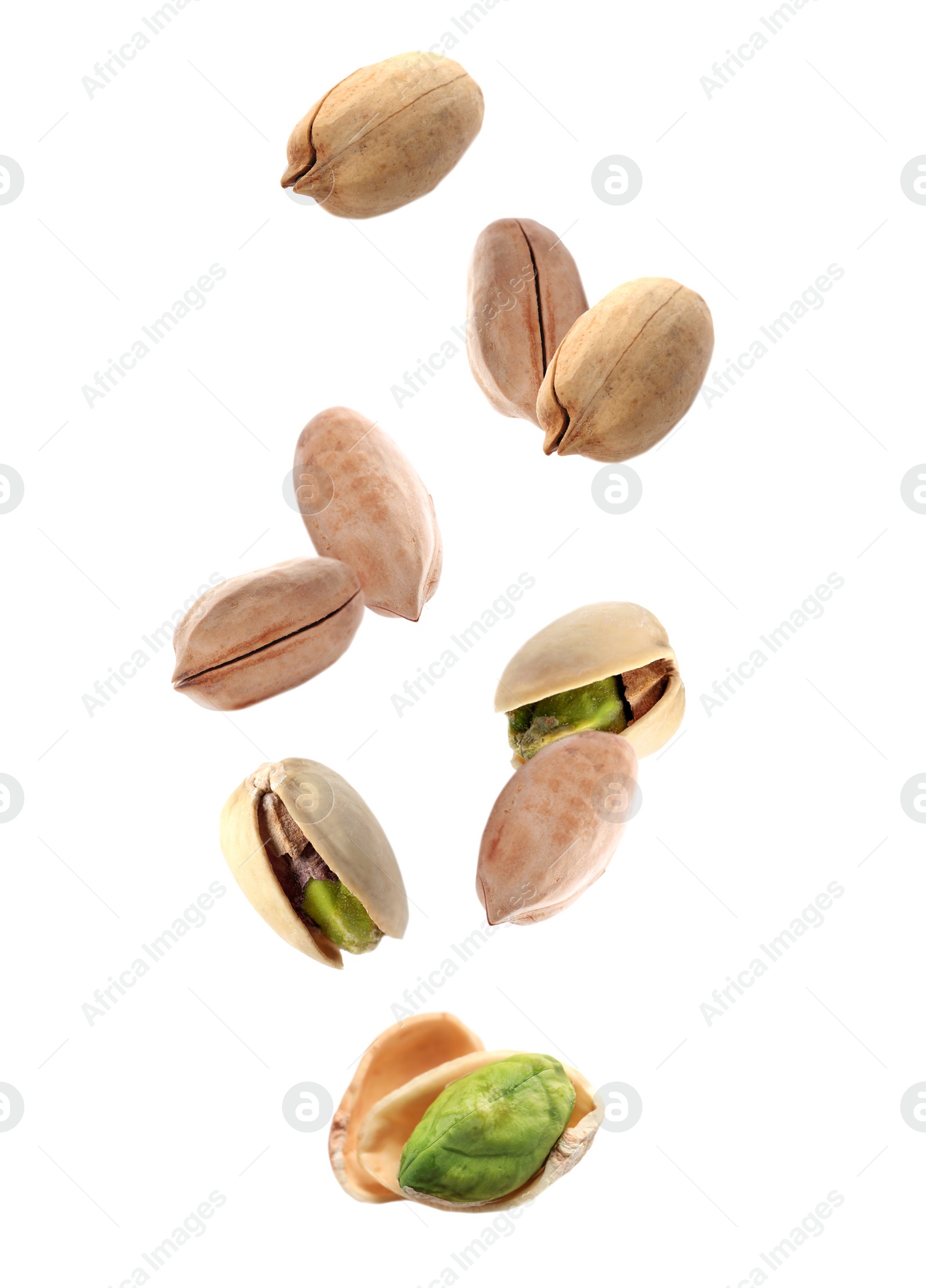 Image of Tasty pistachio nuts falling on white background 