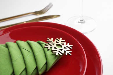 Festive table setting with green napkin folded in shape of Christmas tree on white background, closeup