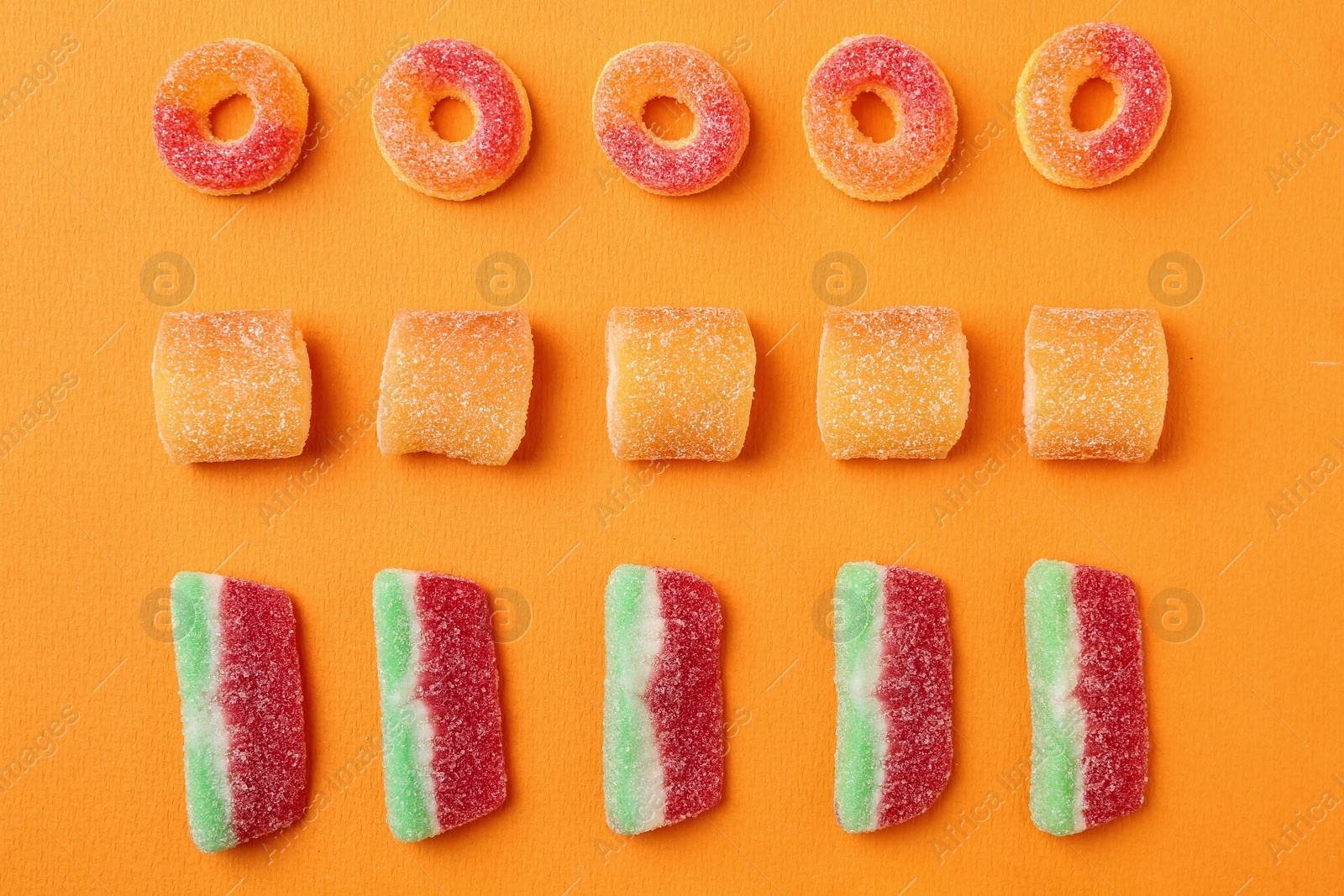 Photo of Flat lay composition with delicious jelly candies on color background