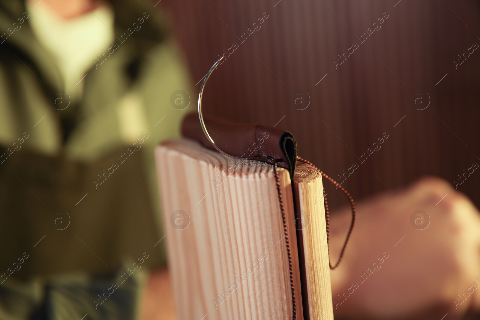 Photo of Piece of leather with needle and thread, closeup