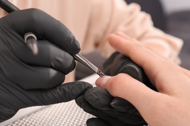 Professional manicurist working with client, closeup view