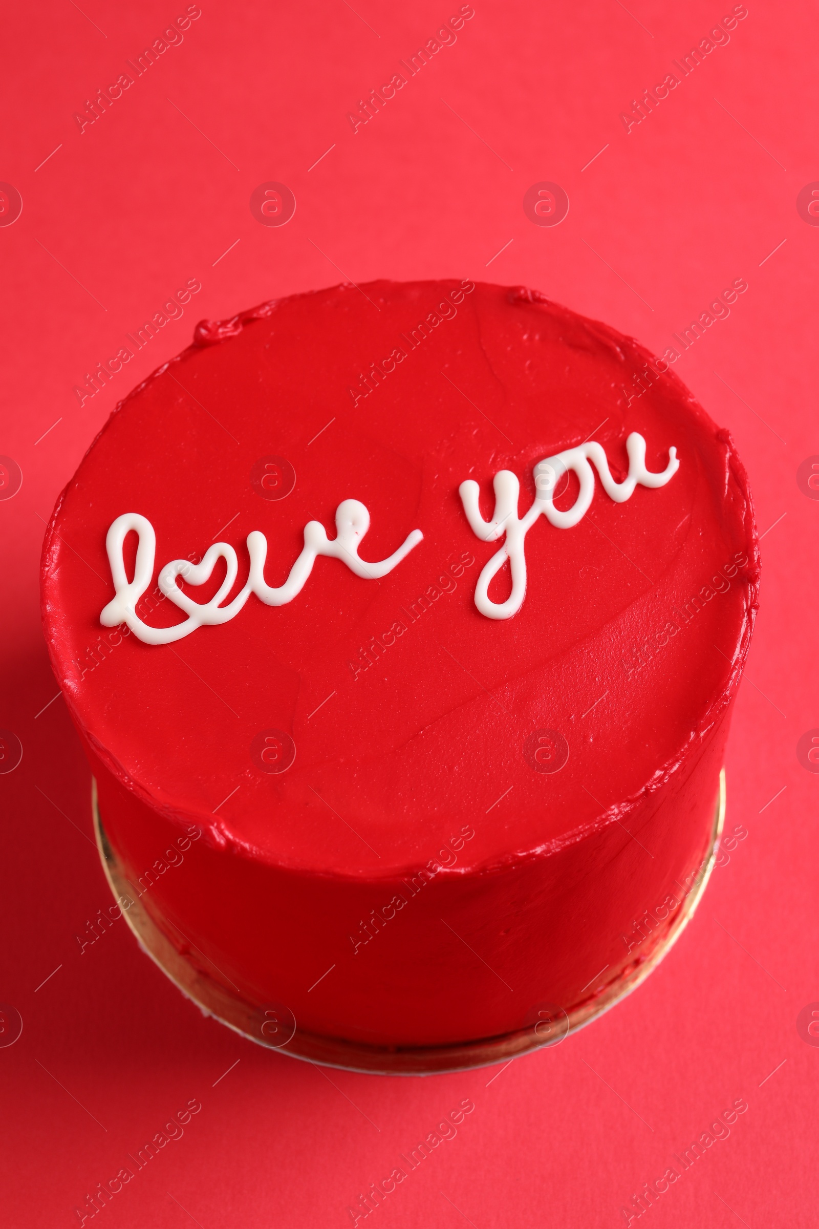 Photo of Bento cake with text Love You on red table, closeup. St. Valentine's day surprise