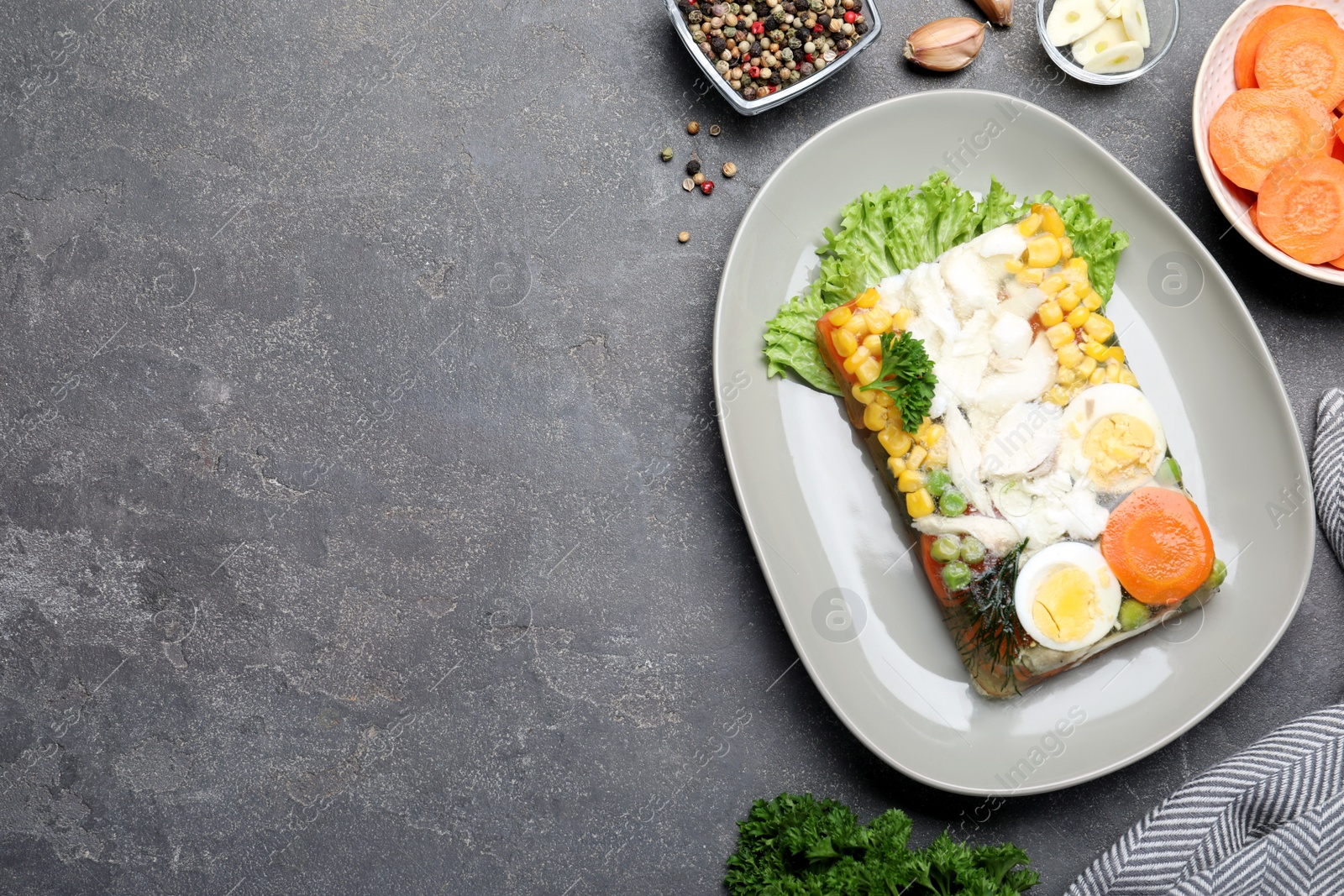 Photo of Delicious fish aspic served on grey table, flat lay. Space for text