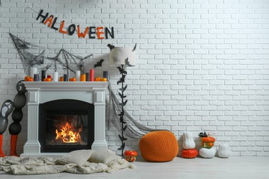 Photo of Room with fireplace decorated for Halloween, space for text. Festive interior