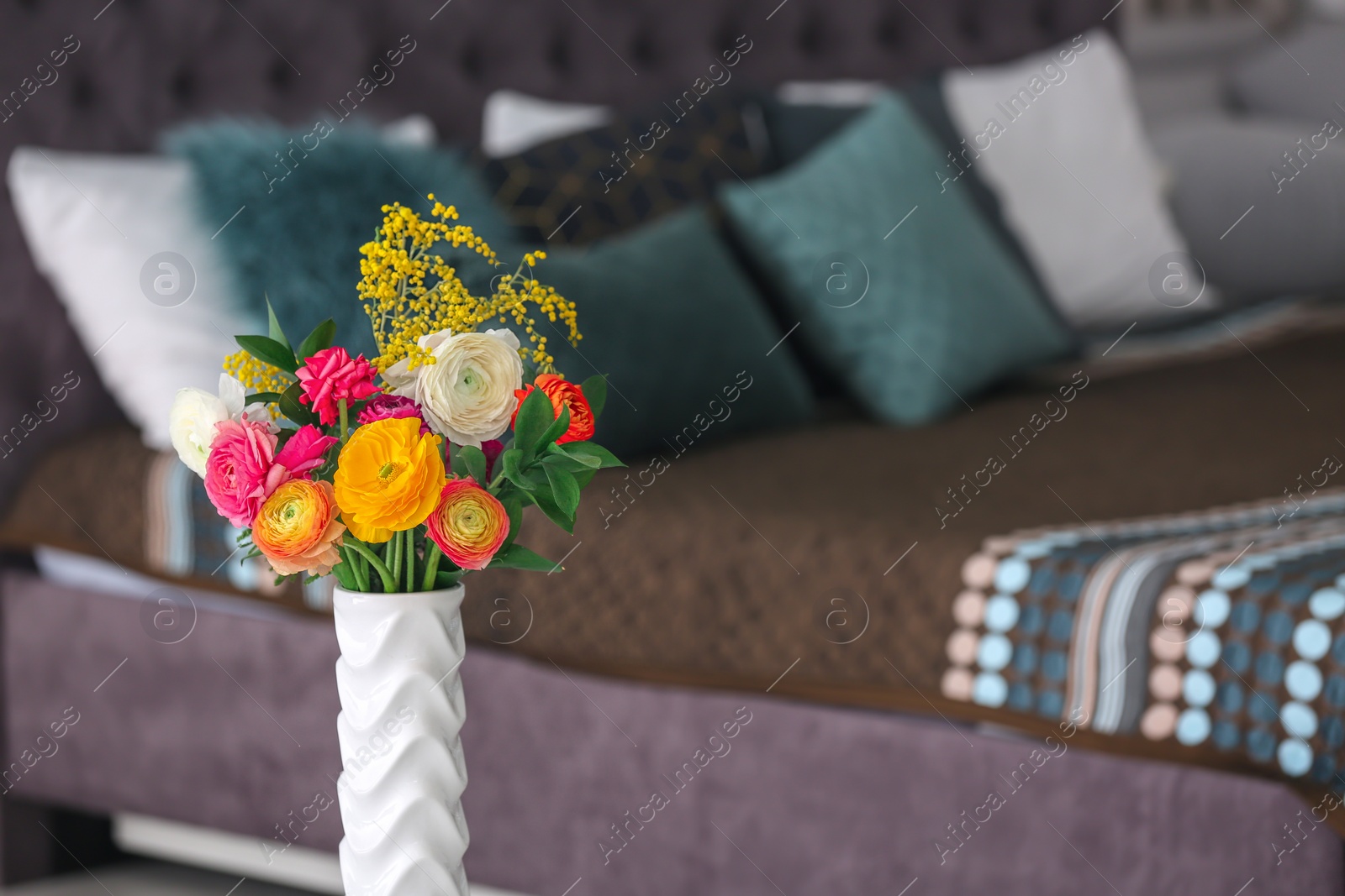 Photo of Vase with beautiful ranunculus flowers on blurred background