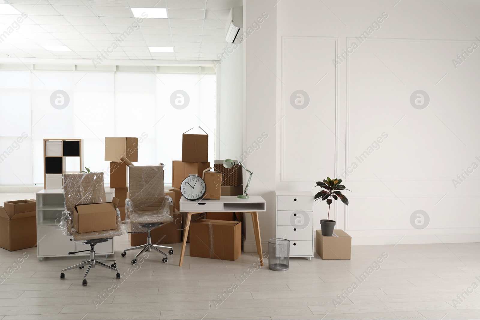 Photo of Cardboard boxes and packed stuff in office. Moving day