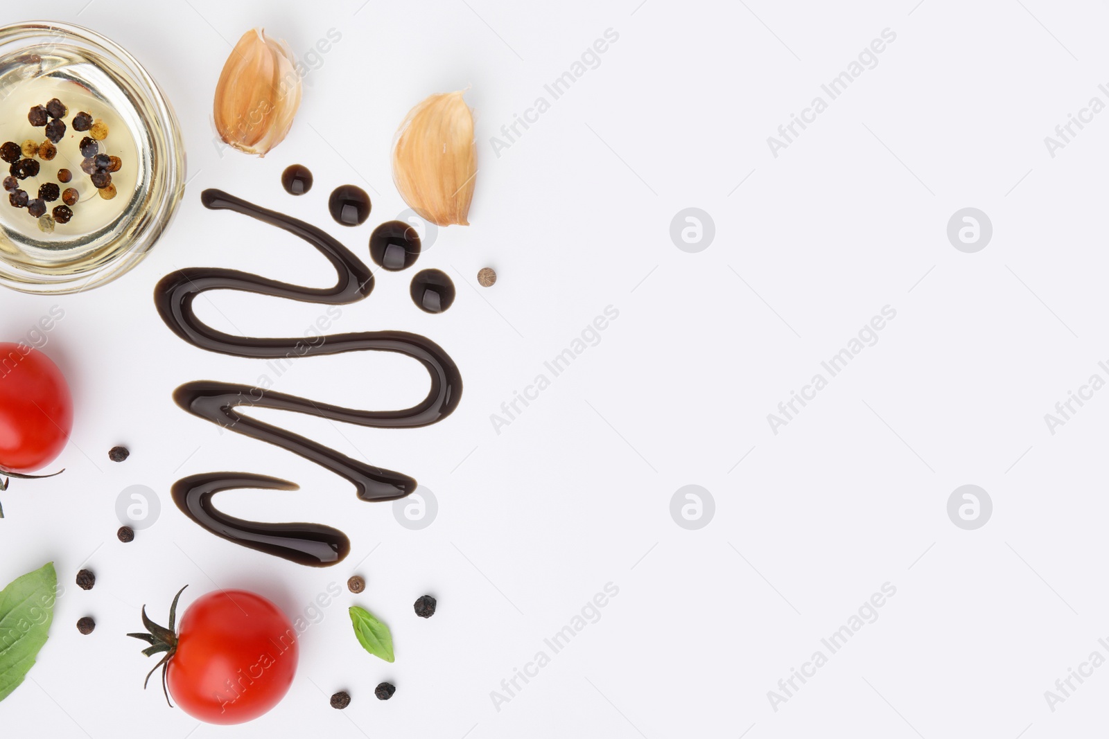 Photo of Organic balsamic vinegar and cooking ingredients on white background, flat lay. Space for text