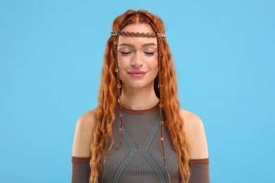 Photo of Beautiful young hippie woman on light blue background