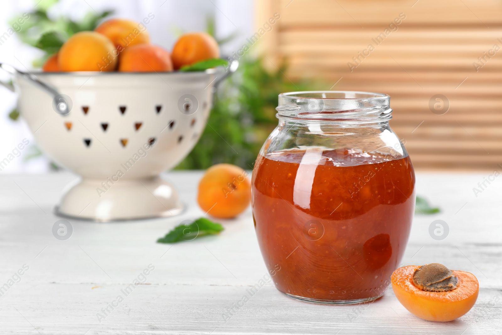 Photo of Jar with tasty apricot jam on table