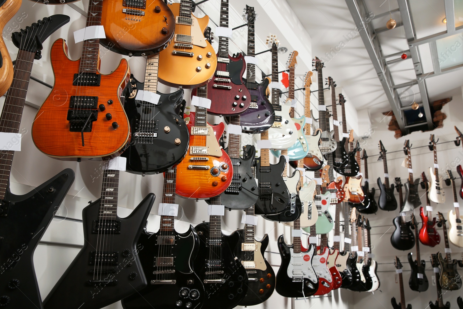 Photo of Rows of different guitars in music store, low angle view