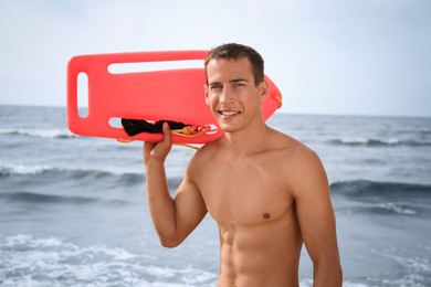 Photo of Handsome lifeguard with life buoy near sea