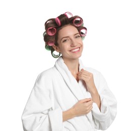 Beautiful young woman in bathrobe with hair curlers on white background