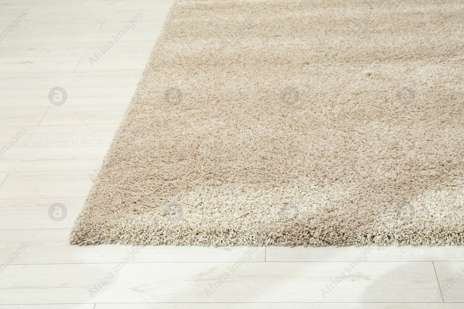 Photo of Soft beige carpet on white laminated floor indoors