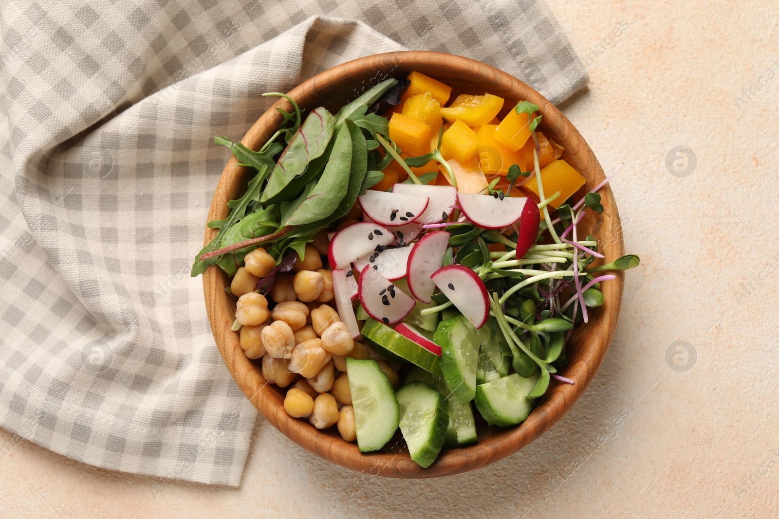 Photo of Delicious vegan bowl with cucumbers, chickpeas and radish on beige table, top view