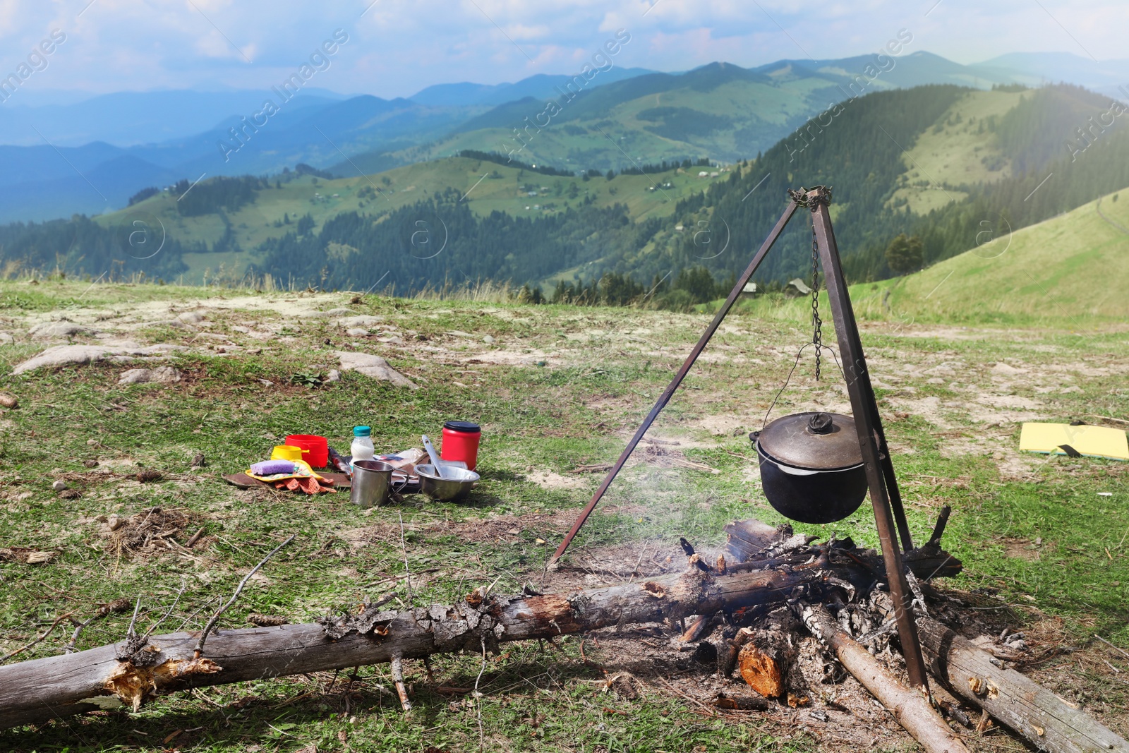 Photo of Cooking breakfast on fire in mountains. Camping season