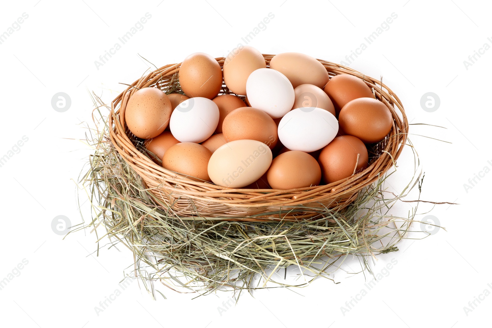 Photo of Fresh chicken eggs in wicker basket and dried hay isolated on white