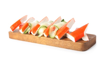 Wooden board with crab sticks and cucumber on white background