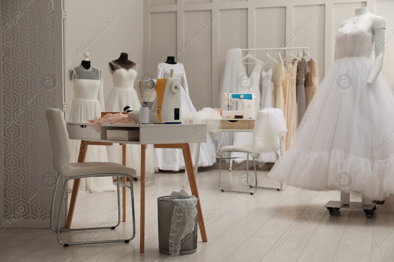 Photo of Dressmaking workshop interior with wedding dresses and equipment