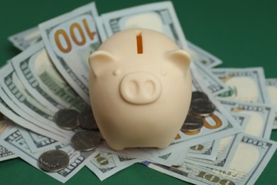 Money exchange. Dollar banknotes, piggy bank and coins on green background, closeup
