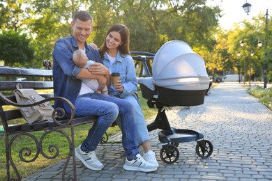 Happy parents with their baby on bench in park