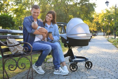 Photo of Happy parents with their baby on bench in park