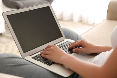 Woman working with modern laptop indoors, closeup. Space for design