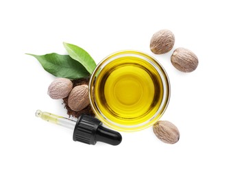 Photo of Bowl of nutmeg oil, pipette and nuts on white background, top view