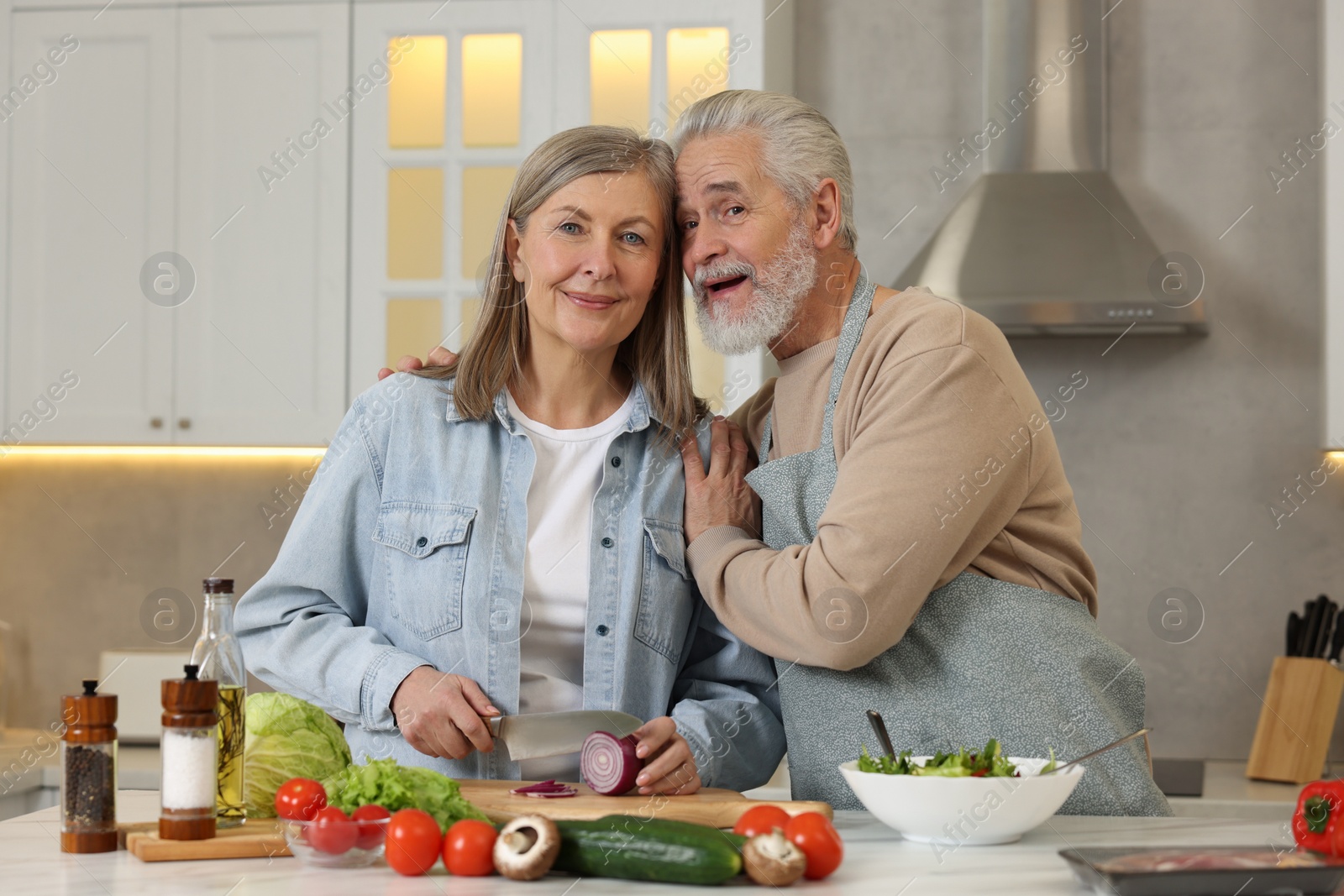 Photo of Happy senior couple cooking together in kitchen