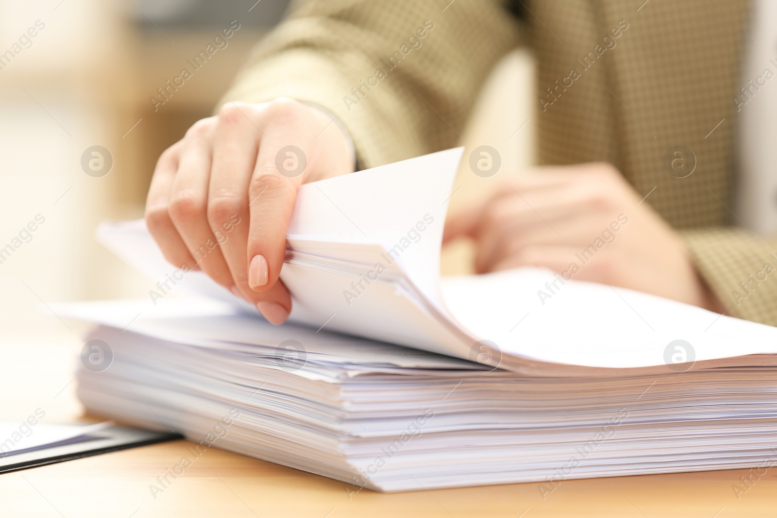 Photo of Woman working with documents at table in office, closeup