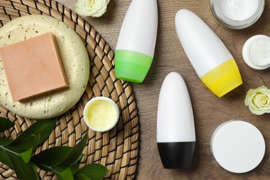 Photo of Flat lay composition with natural roll-on deodorants on wooden table