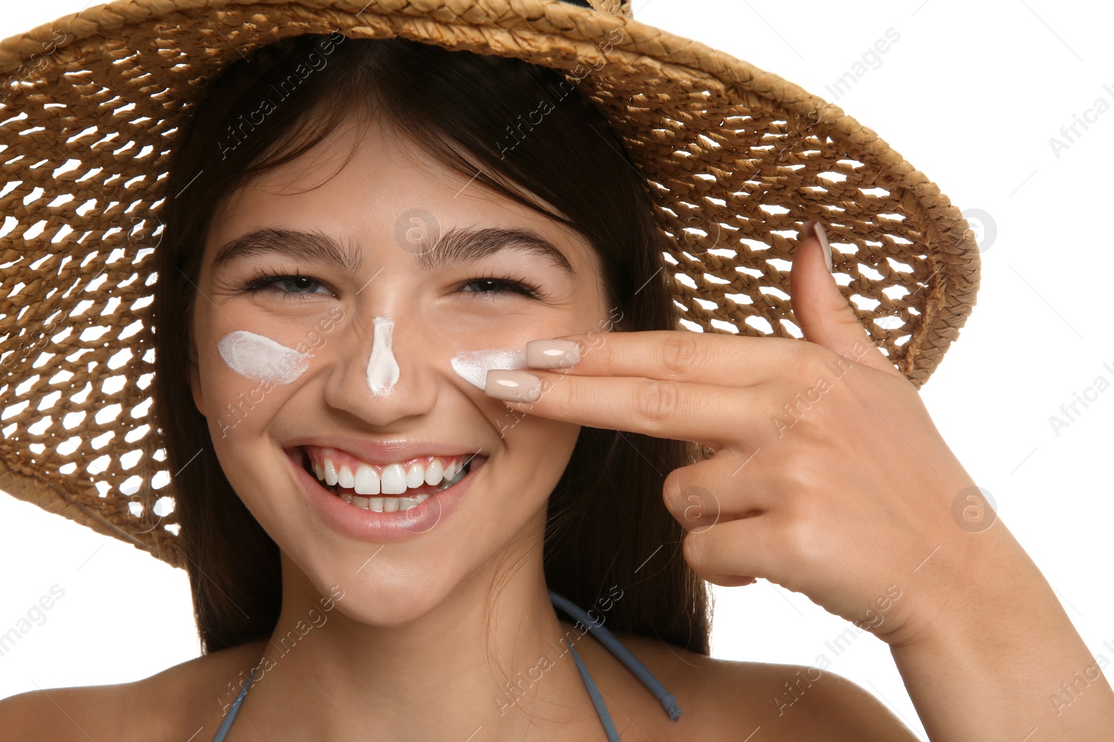 Photo of Teenage girl applying sun protection cream on her face against white background, closeup