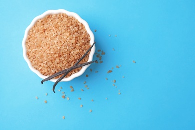 Photo of Bowl with brown vanilla sugar on color background, top view