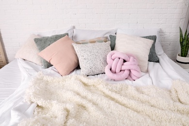 Photo of Different pillows on bed in room. Idea for interior decor