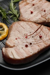 Delicious tuna steaks with spices in grill pan, closeup