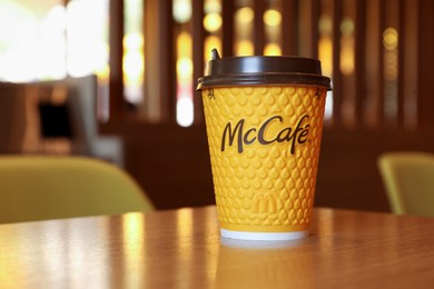 Photo of MYKOLAIV, UKRAINE - AUGUST 11, 2021: Hot McDonald's drink on table in cafe. Space for text