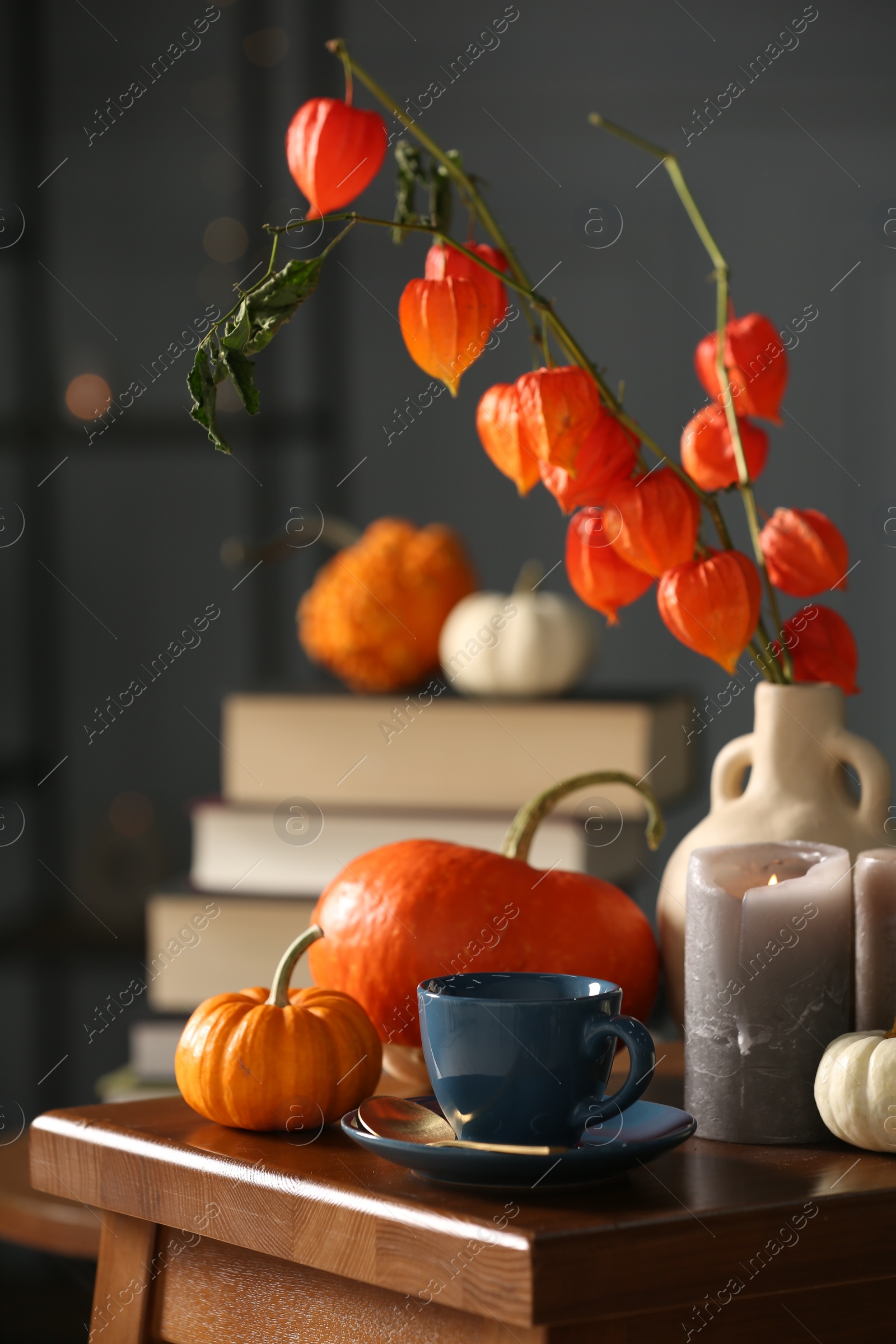 Photo of Beautiful autumn composition with cup of drink and pumpkins on wooden table indoors