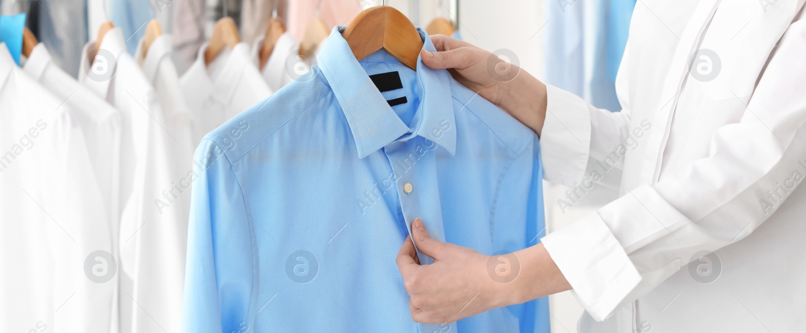 Image of Young woman holding hanger with shirt, banner design. Dry-cleaning service