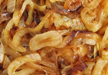 Tasty fried onion as background, top view