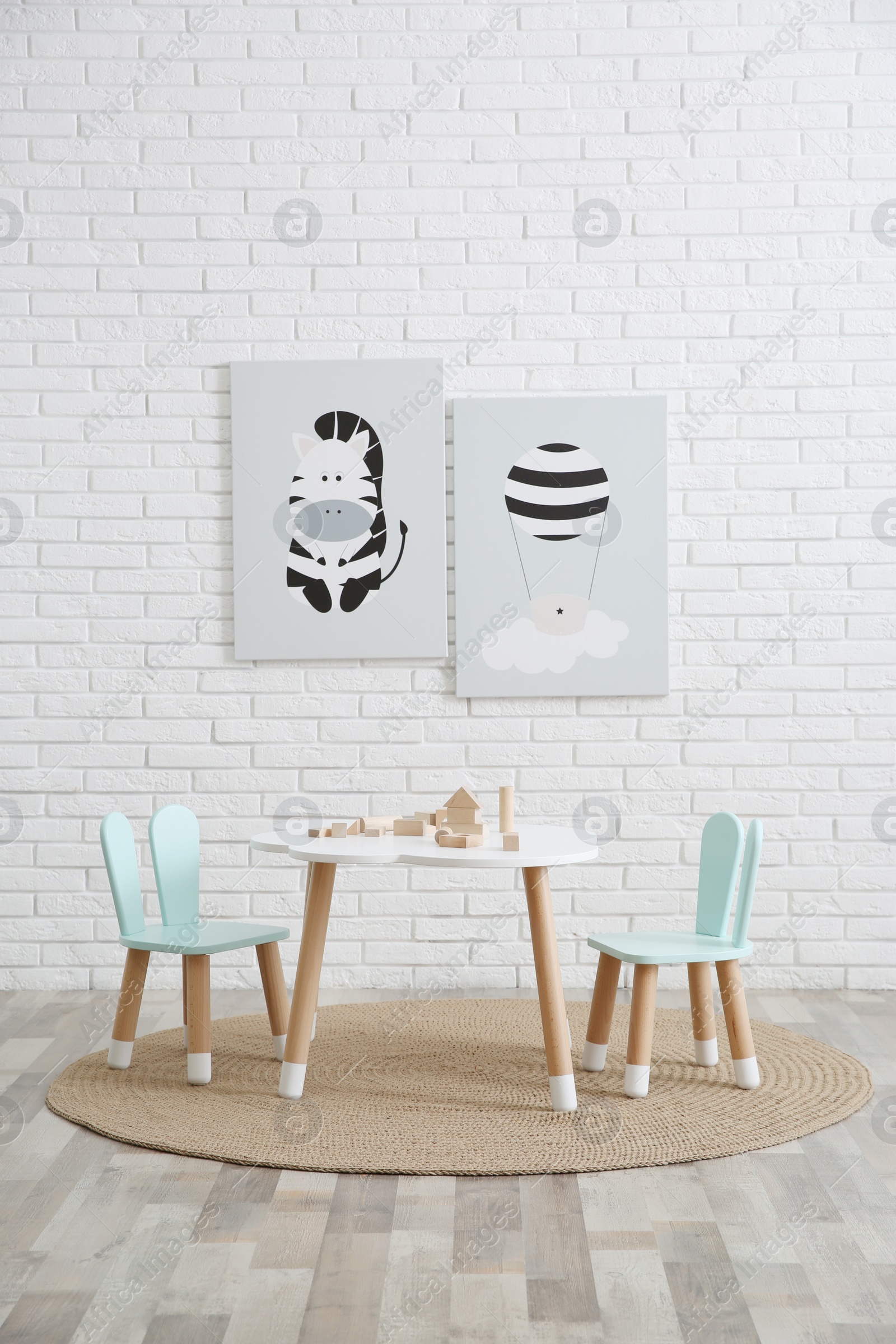 Photo of Little table and chairs with bunny ears in children's room. Interior design