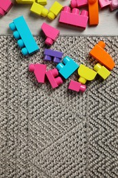 Colorful plastic building blocks on floor, flat lay. Space for text