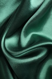 Photo of Crumpled green silk fabric as background, closeup