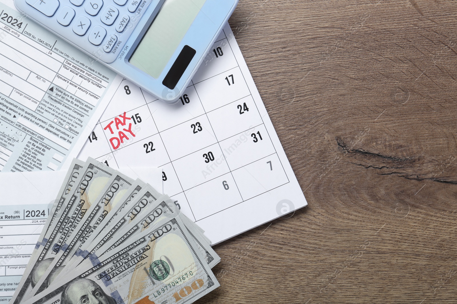 Photo of Calendar with date reminder about tax day, documents, money and calculator on wooden table, top view. Space for text