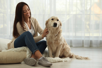 Photo of Young woman and her Golden Retriever at home. Adorable pet