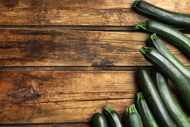 Photo of Green ripe zucchinis on wooden table, flat lay. Space for text