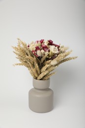 Photo of Beautiful bouquet of dry flowers in ceramic vase on white background