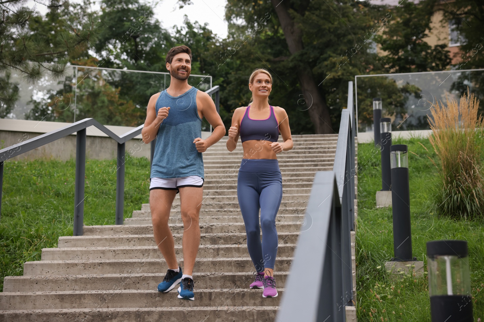 Photo of Healthy lifestyle. Happy couple running down stairs outdoors